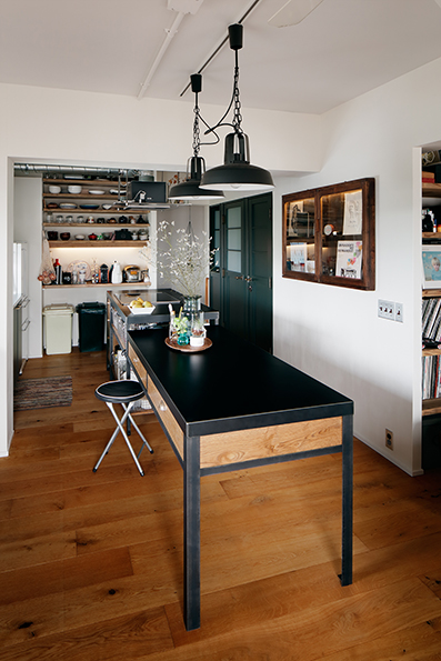 オープンな鉄製のキッチン<br />奥には古材のオープン棚