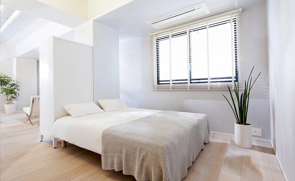 寝室とリビングは柱と家具で緩やかに区切られる