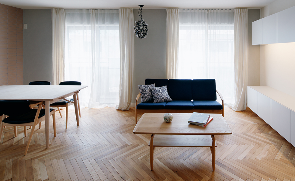 ヘリンボーンの床が美しいリビングダイニング<br />壁はグレーの珪藻土　天井は白の珪藻土