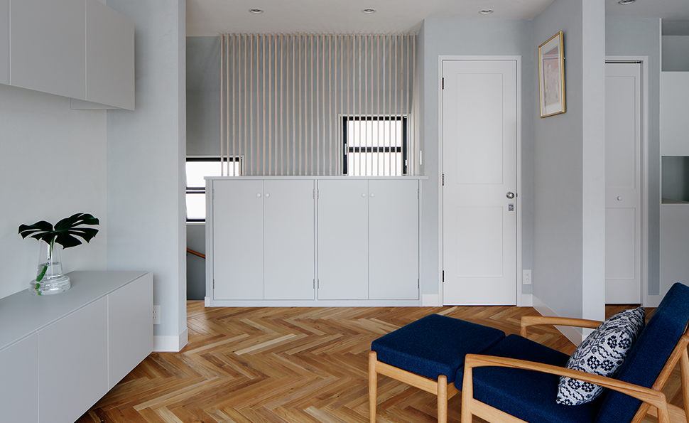 突き当たりの収納は既存<br />既存収納の上にルーバーを設置し奥の階段と緩やかにつなげる