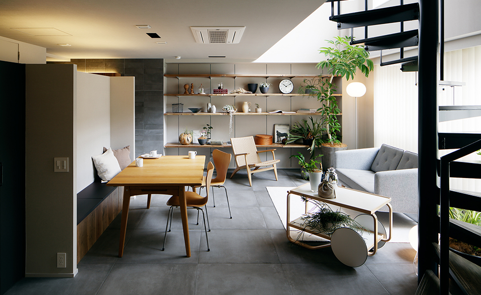 吹き抜けが特徴的なリビングダイニング<br />床は大判のタイル 左奥にキッチンがある 吹き抜けが特徴的なリビングダイニング<br />床は大判のタイル 左奥にキッチンがある