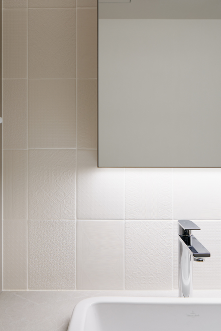 洗面の壁にはレースのような繊細な柄のタイル