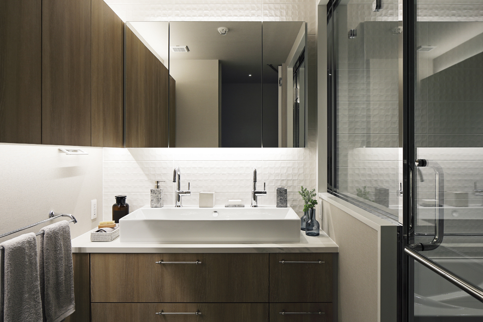 L型の吊収納がある洗面所　右側に浴室が続く