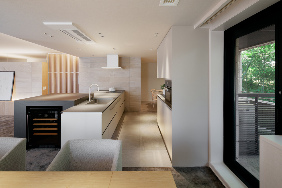 キッチンをみる　奥にファミリーダイニングが続いているのが見える