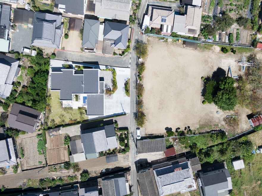 市街地の住宅街　公道を挟んで東側に開けた公園がある