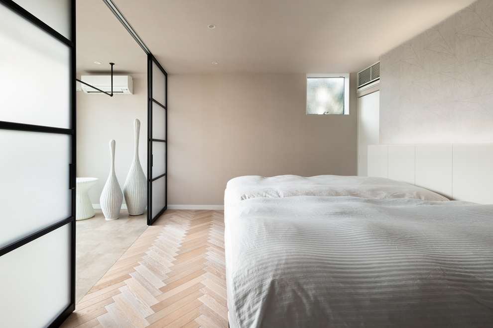 ファミリーリビングに続く主寝室　左側はランドリー乾燥部屋　ベッドボード裏は大容量のWIC