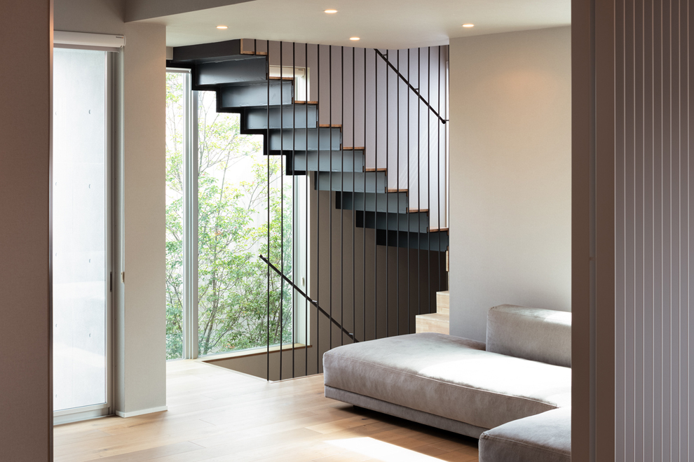 1階から3階まで続く階段 奥の緑はアプローチ部分の植栽と 1階から3階まで続く階段 奥の緑はアプローチ部分の植栽と